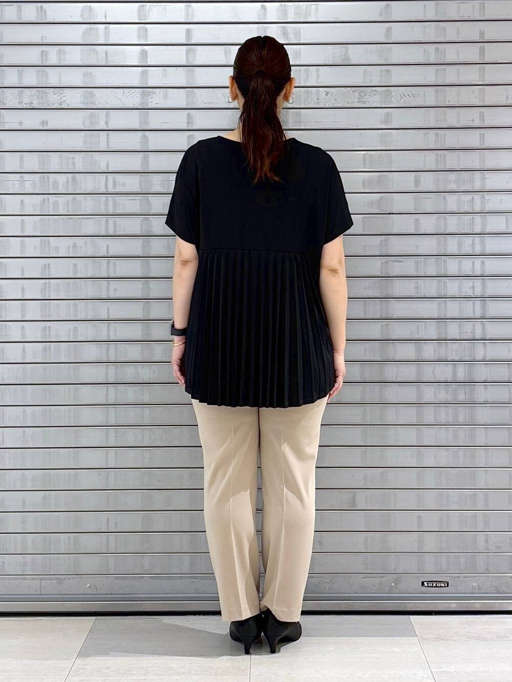 ブラック系のパンプス、ブラック系のハンドバッグ、ベージュ系のその他パンツを着用したレディースの春コーディネートの4枚目の写真