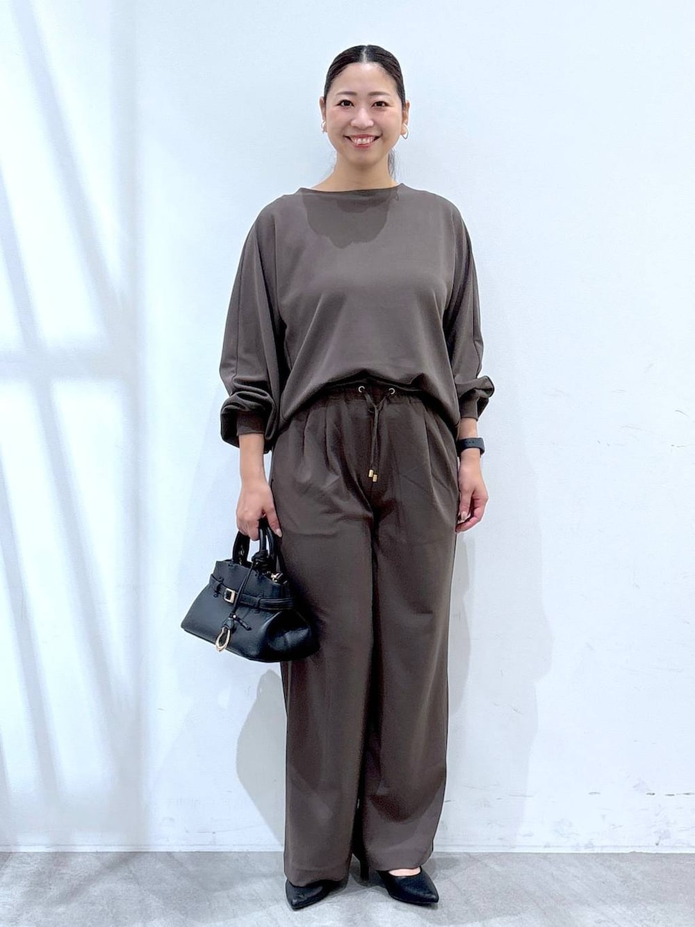 ブラック系のパンプス、ブラウン系のその他パンツ、ブラウン系のTシャツ/カットソーを着用したレディースの秋コーディネートの2枚目の写真