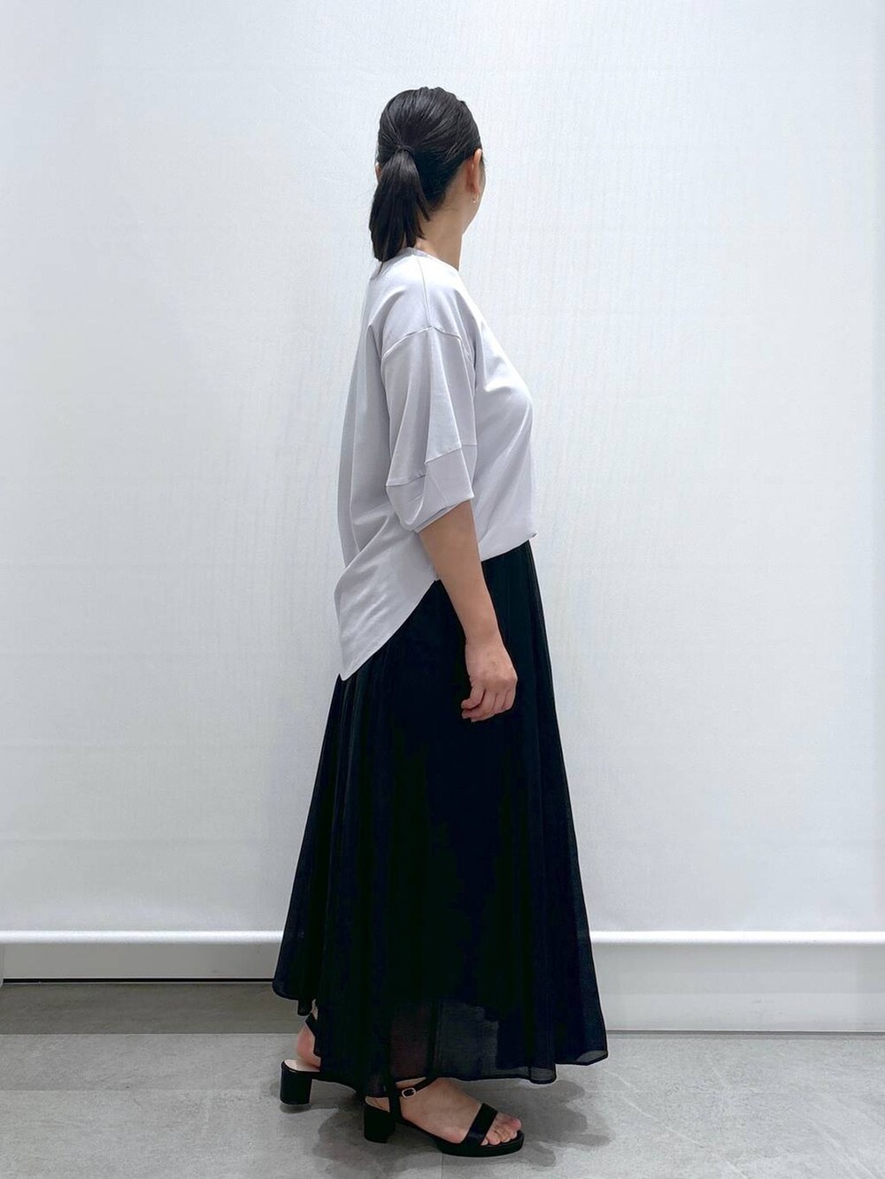 グレー系のTシャツ/カットソー、ブラック系のサンダル、ブラック系のスカートを着用したレディースの夏コーディネートの5枚目の写真