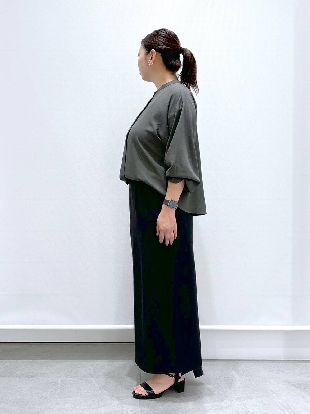 グリーン系のシャツ/ブラウス、ブラック系のサンダル、ブラック系のスカートを着用したレディースの秋コーディネートの2枚目の写真