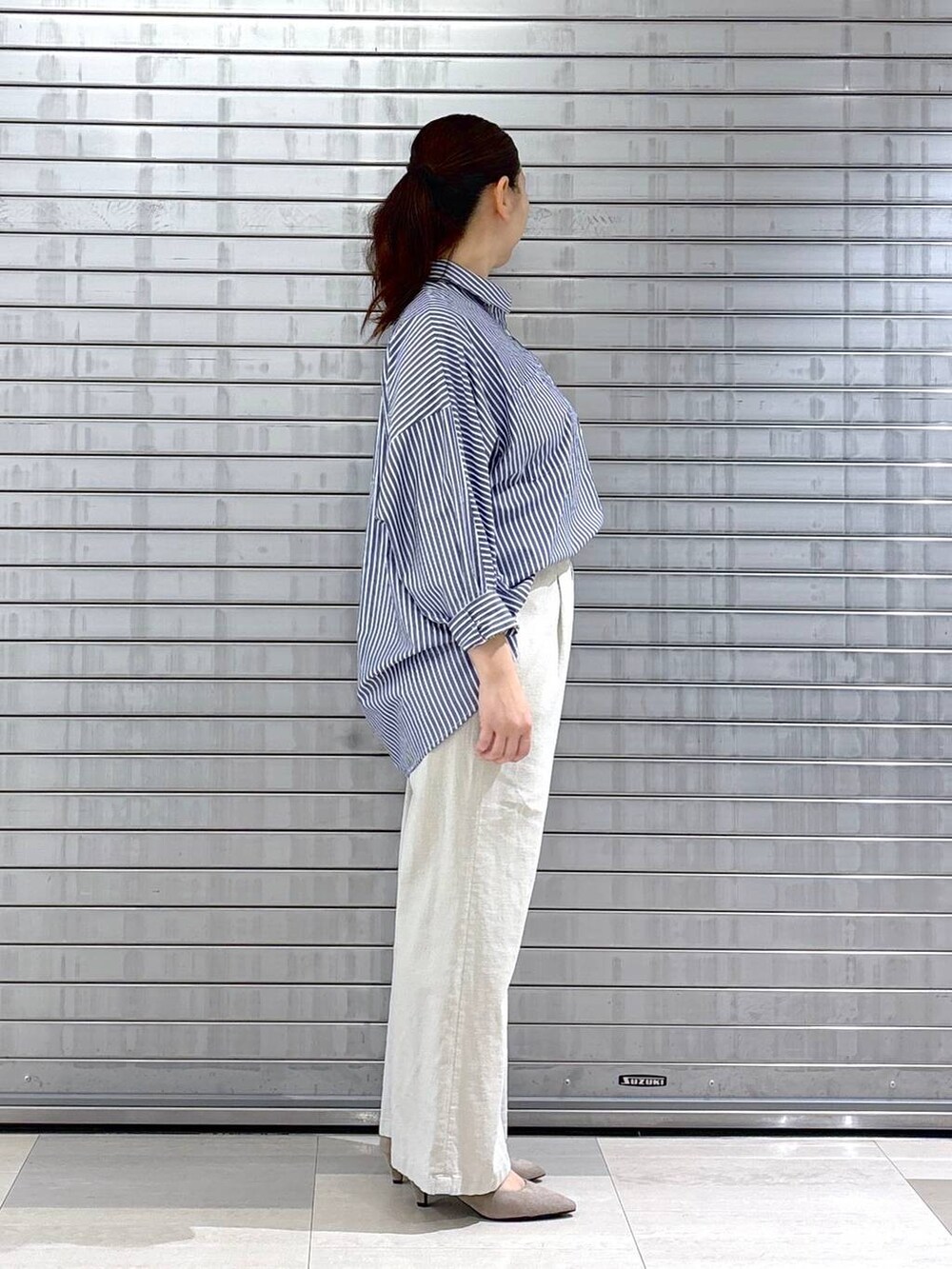 ベージュ系のパンプス、ベージュ系のハンドバッグ、イエロー系のニット/セーターを着用したレディースの春コーディネートの4枚目の写真