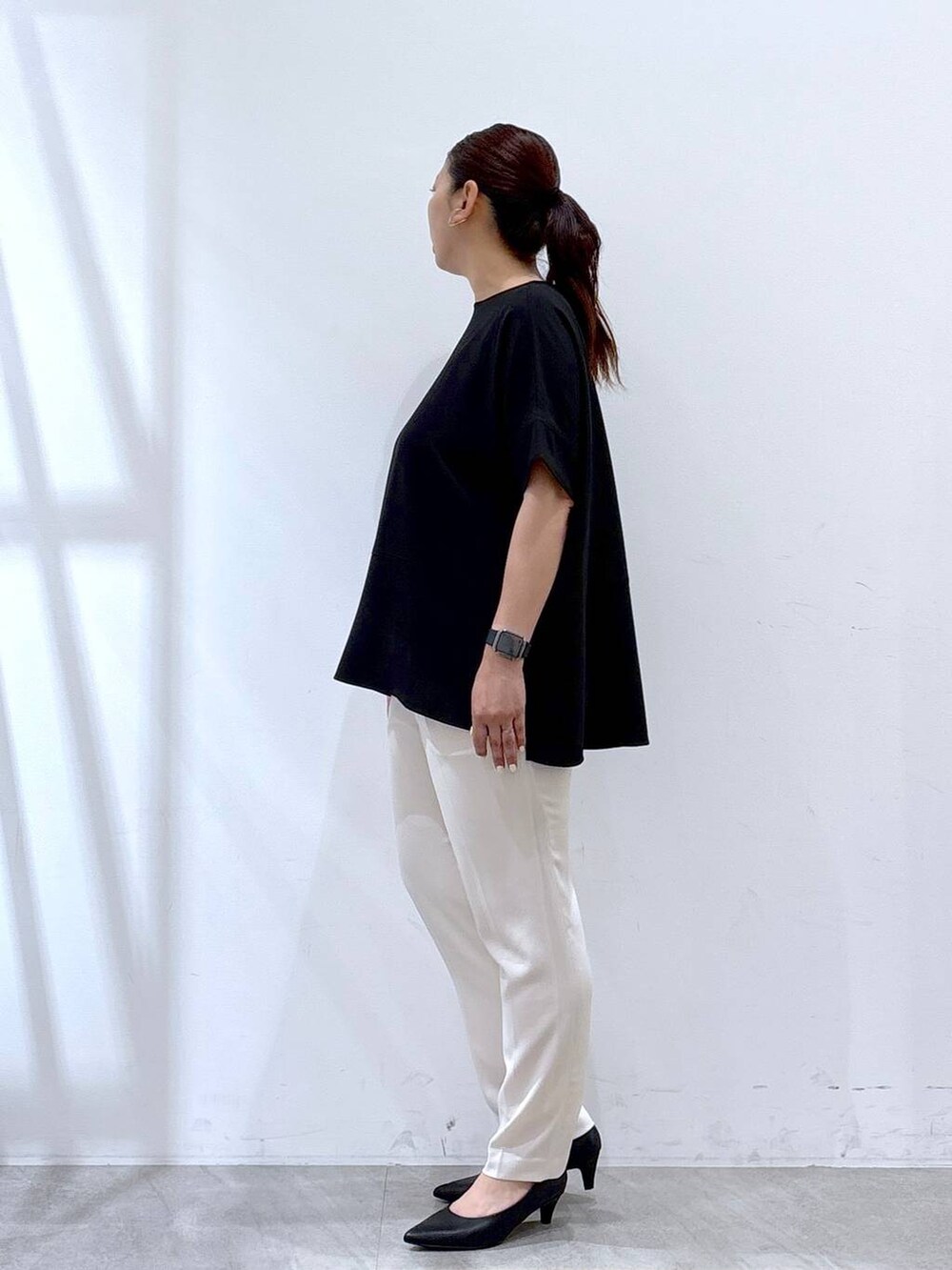 ブラック系のパンプス、ホワイト系のその他パンツ、ブラック系のハンドバッグを着用したレディースの夏コーディネートの2枚目の写真