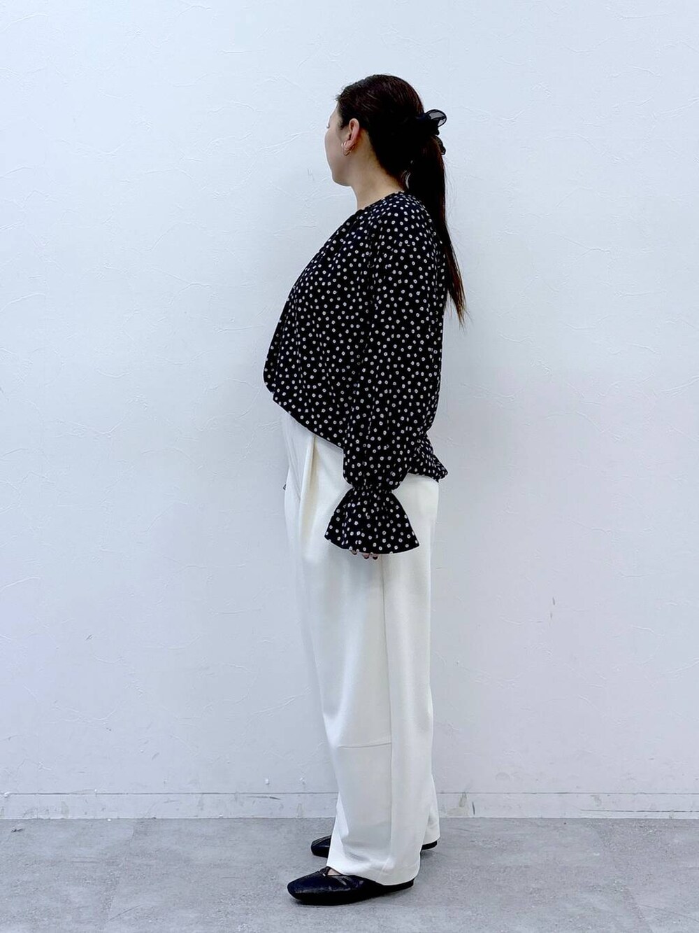 ブラック系のハンドバッグ、ブラック系のパンプス、ブラック系のシャツ/ブラウスを着用したレディースの冬コーディネートの3枚目の写真