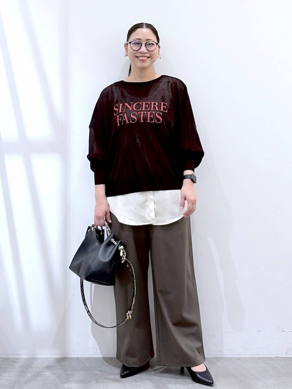 ブラック系のハンドバッグ、グリーン系のその他パンツ、ホワイト系のタンクトップを着用したレディースの春コーディネートの2枚目の写真