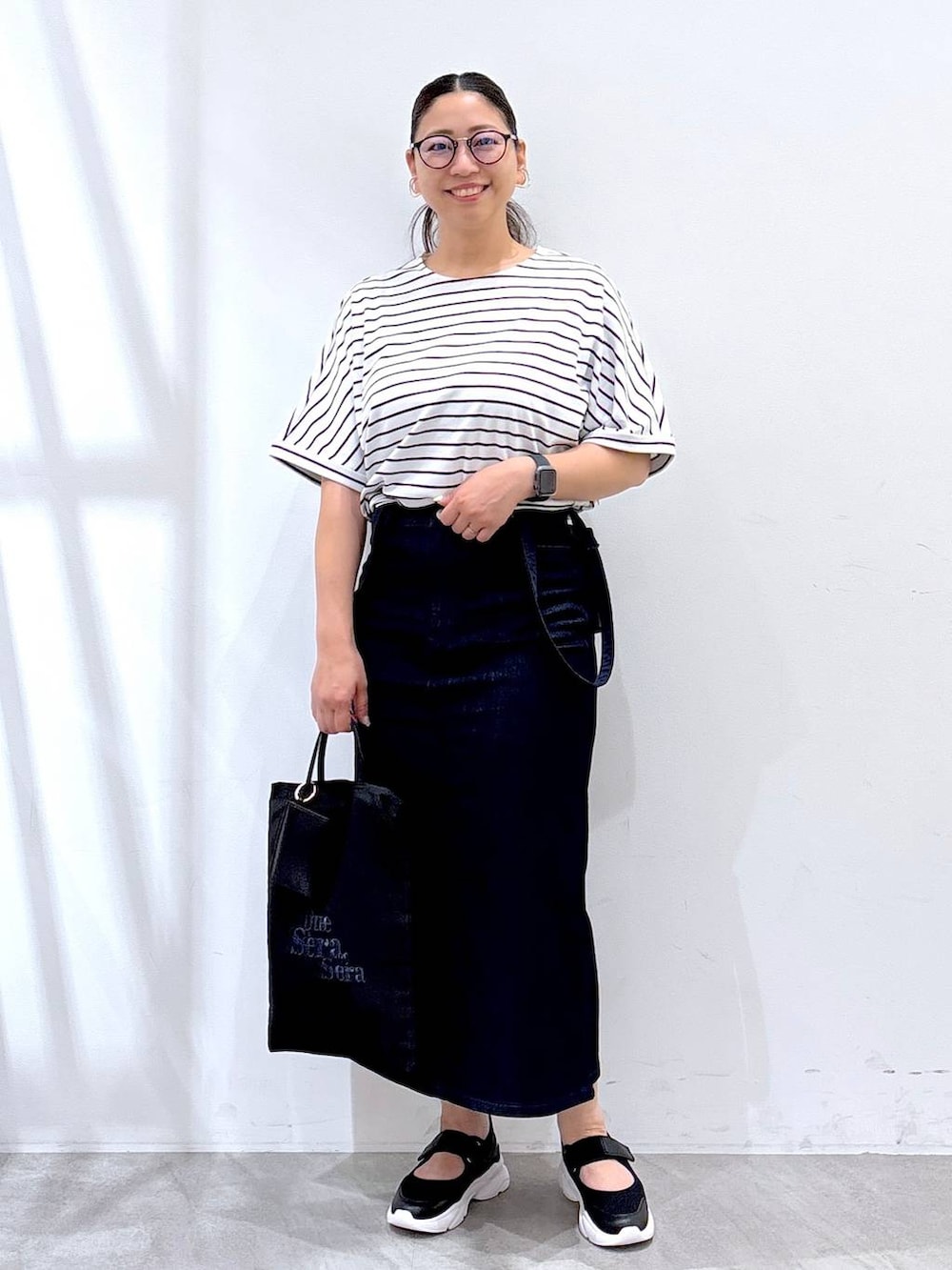 ホワイト系のTシャツ/カットソー、ブラック系のトートバッグ、ブラック系のサンダルを着用したレディースの夏コーディネートの2枚目の写真