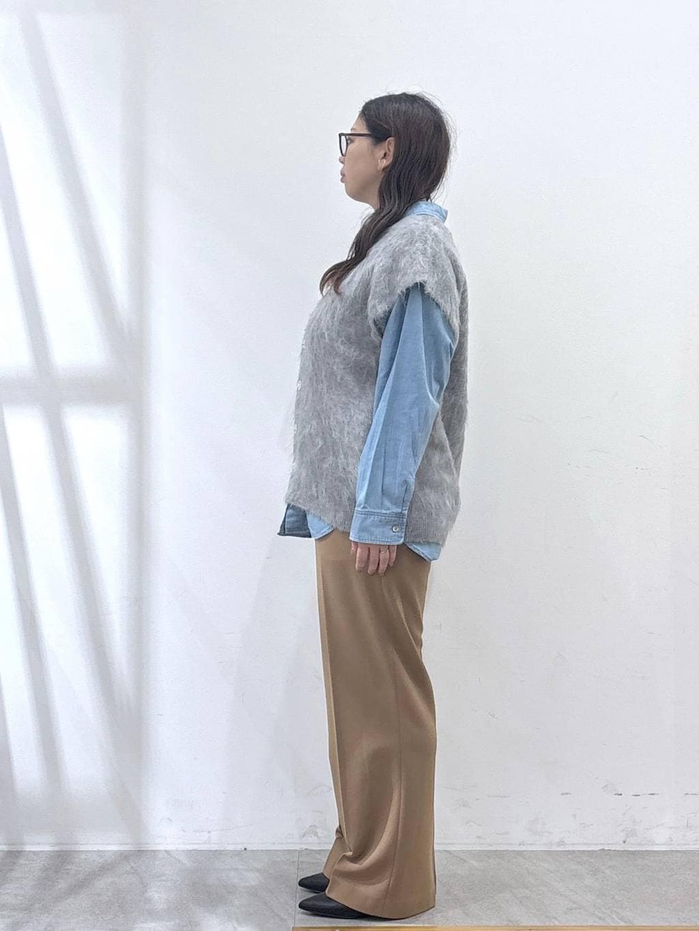 ブラック系のパンプス、ブルー系のシャツ/ブラウス、イエロー系のその他パンツを着用したレディースの冬コーディネートの3枚目の写真