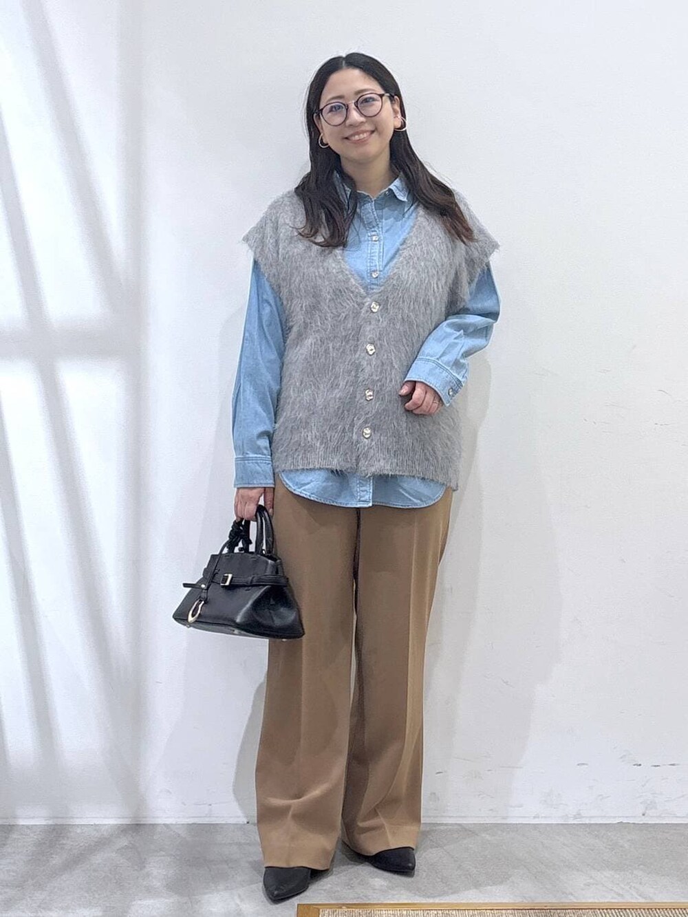 ブラック系のパンプス、ブルー系のシャツ/ブラウス、イエロー系のその他パンツを着用したレディースの冬コーディネートの2枚目の写真