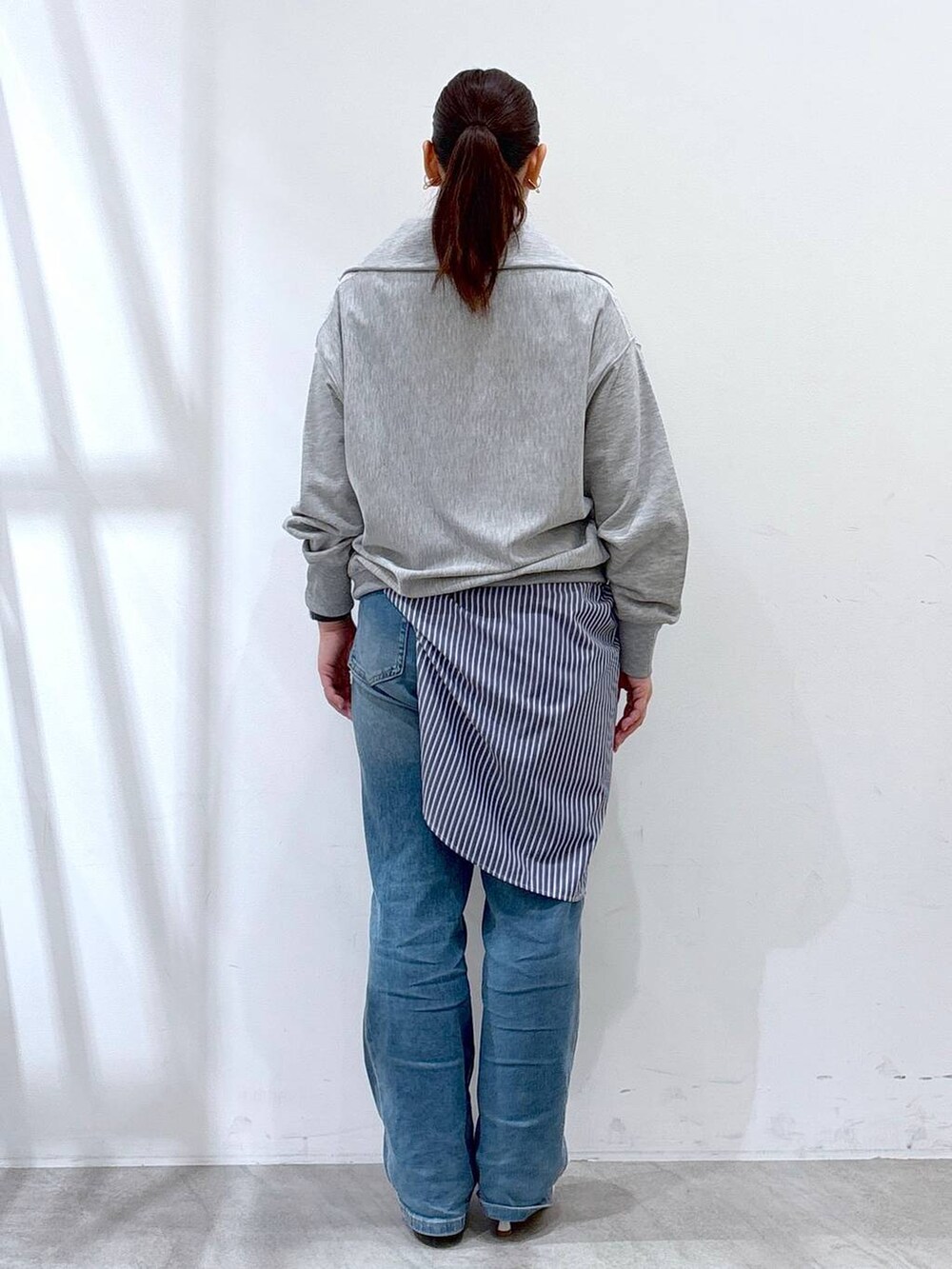 ホワイト系のハンドバッグ、ブルー系のデニムパンツ、グレー系のTシャツ/カットソーを着用したレディースの春コーディネートの4枚目の写真