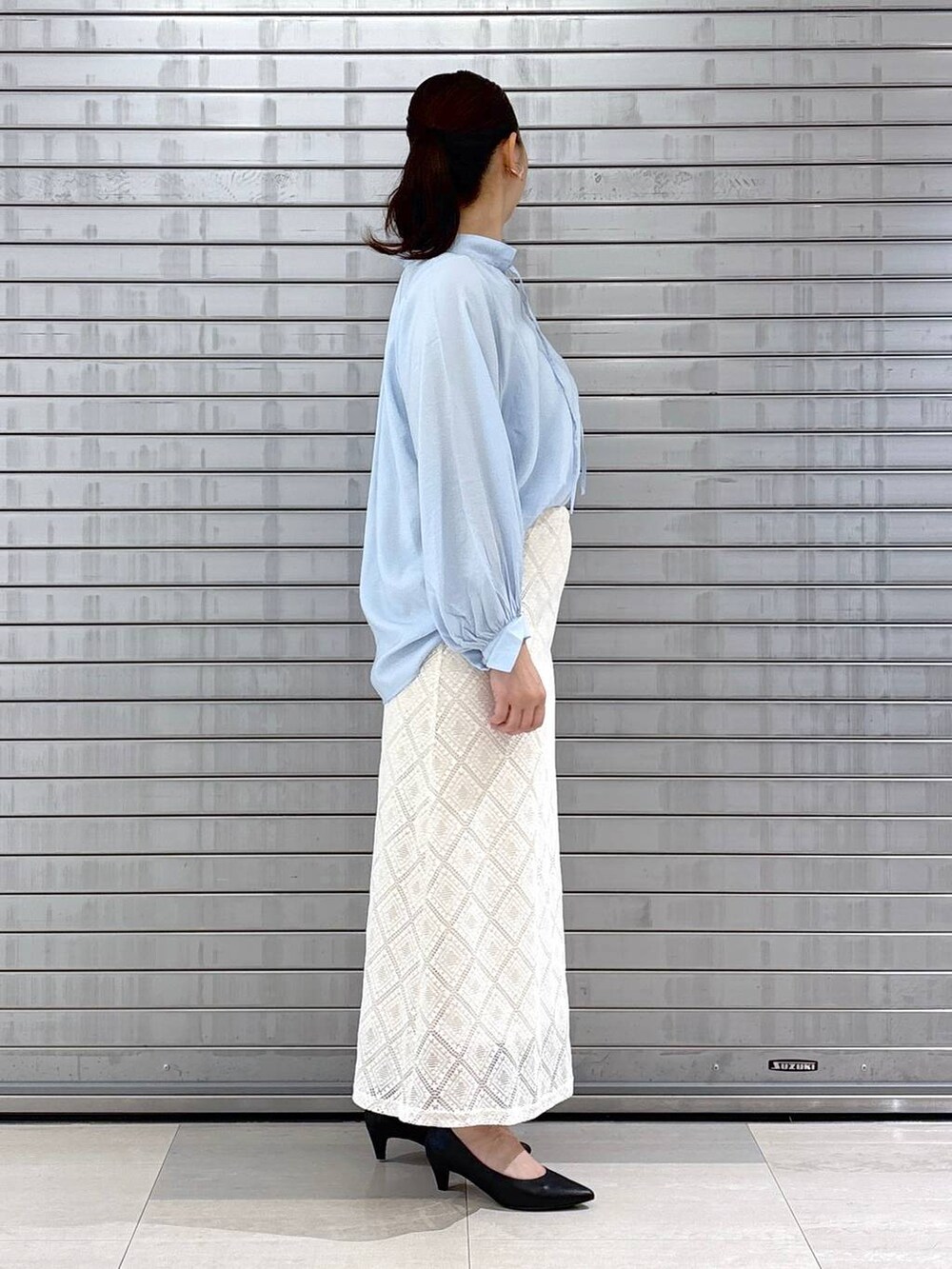 ブラック系のパンプス、ブラック系のハンドバッグ、ブルー系のシャツ/ブラウスを着用したレディースの春コーディネートの5枚目の写真