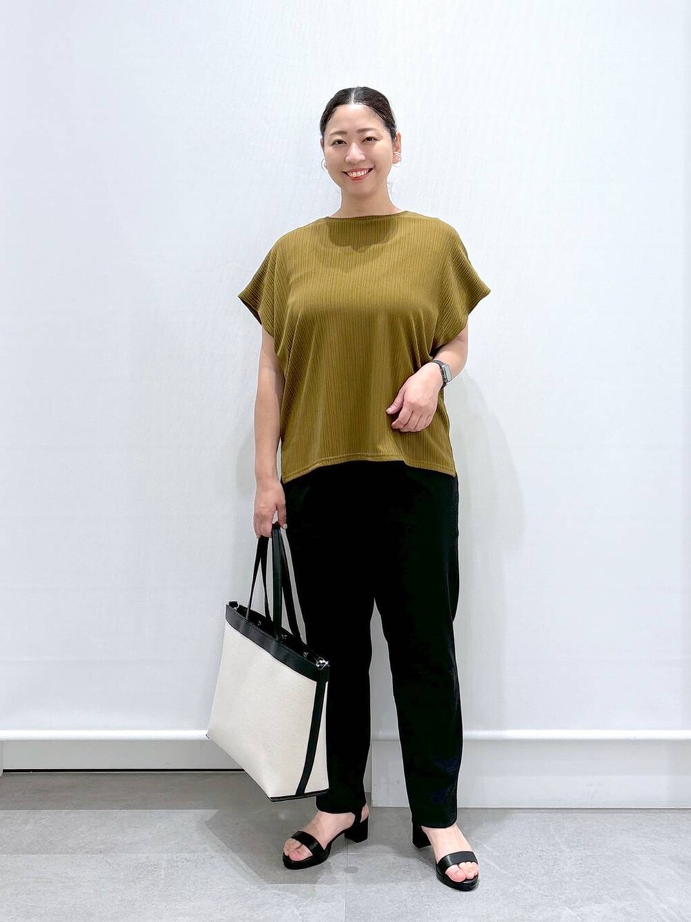 ブラック系のその他パンツ、グリーン系のTシャツ/カットソー、ブラック系のサンダルを着用したレディースの夏コーディネートの2枚目の写真