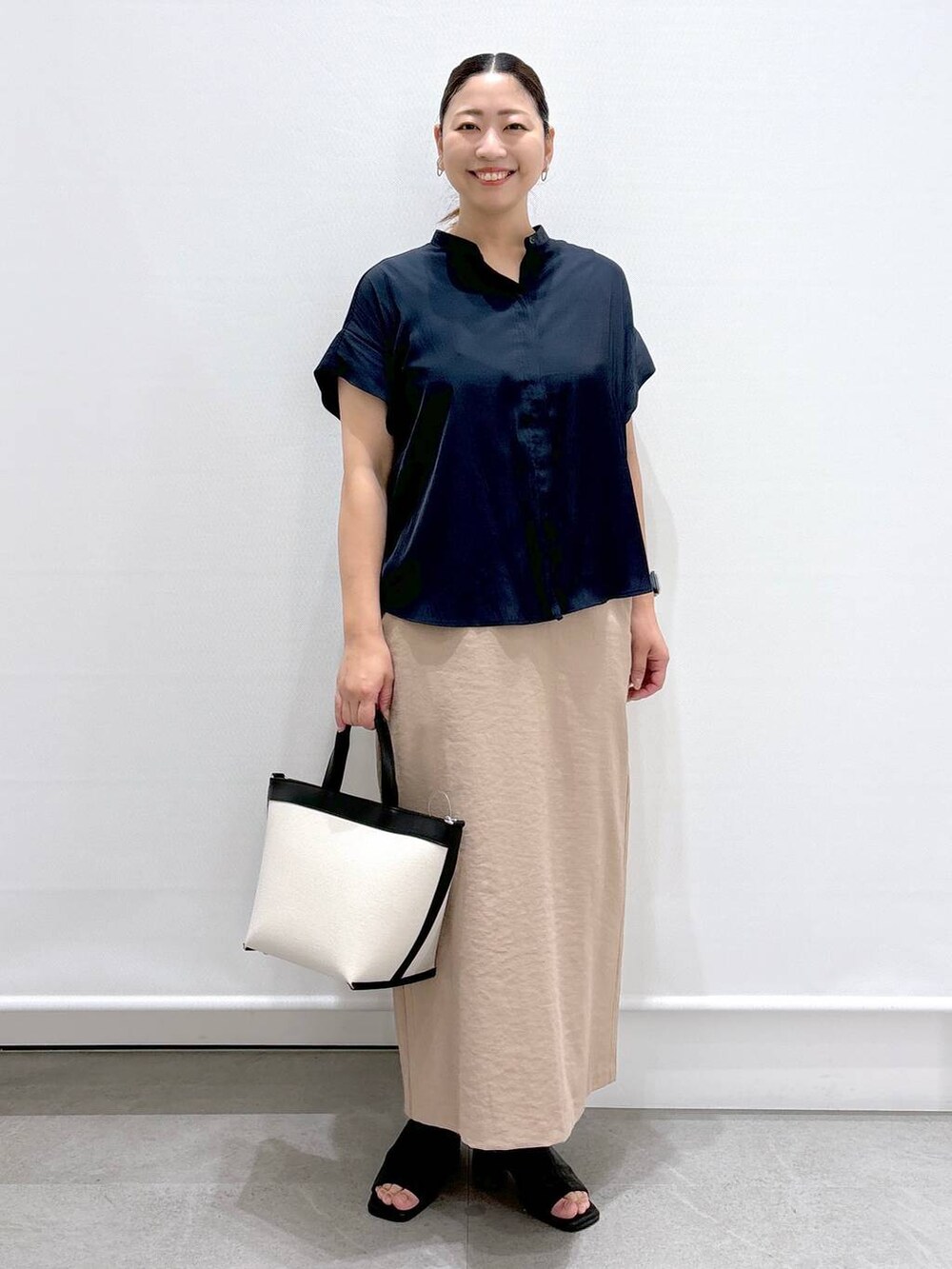 ブルー系のシャツ/ブラウス、ベージュ系のスカート、ブラック系のサンダルを着用したレディースの夏コーディネートの2枚目の写真