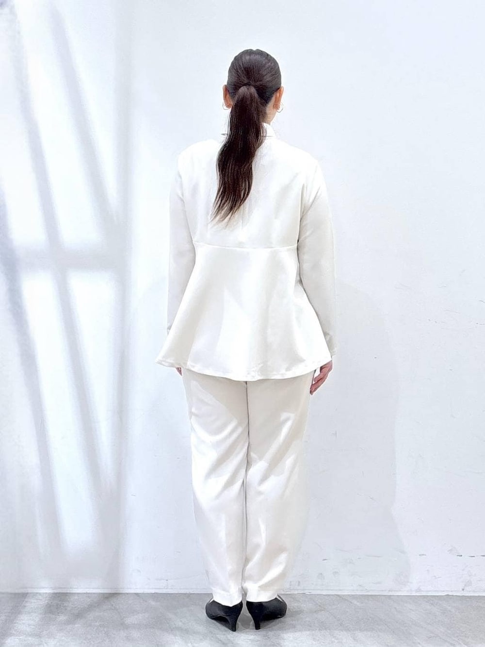 ブラック系のハンドバッグ、ホワイト系のシャツ/ブラウス、ホワイト系のスラックスを着用したレディースの春コーディネートの4枚目の写真