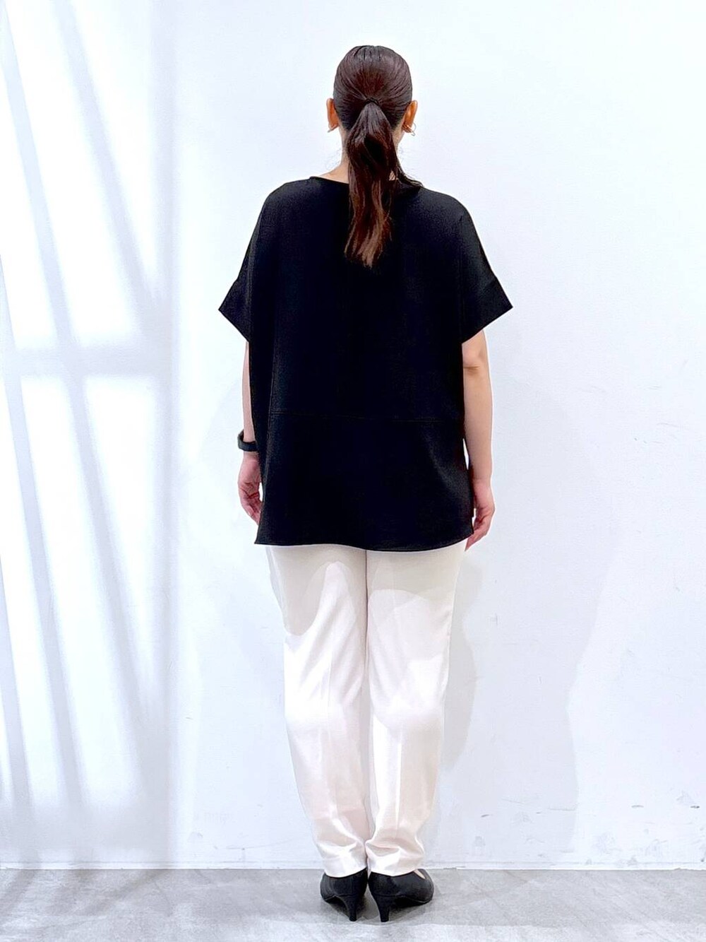 ブラック系のパンプス、ホワイト系のその他パンツ、ブラック系のハンドバッグを着用したレディースの夏コーディネートの3枚目の写真