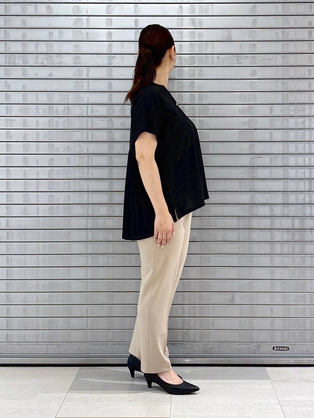 ブラック系のパンプス、ブラック系のハンドバッグ、ベージュ系のその他パンツを着用したレディースの春コーディネートの5枚目の写真