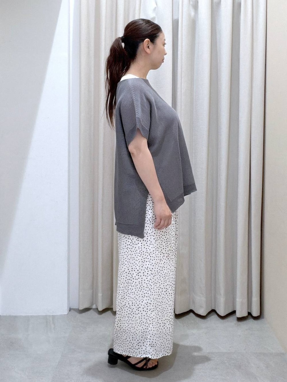 ブラック系のサンダル、ホワイト系のその他パンツ、ブラック系のかごバッグを着用したレディースの夏コーディネートの3枚目の写真