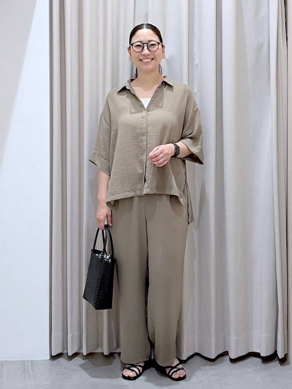 グリーン系のその他パンツ、ホワイト系のタンクトップ、ブラック系のサンダルを着用したレディースの夏コーディネートの2枚目の写真