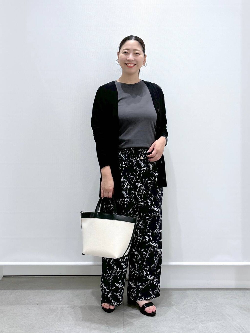 ブラック系のトートバッグ、ブルー系のその他パンツ、ブラック系のサンダルを着用したレディースの夏コーディネートの2枚目の写真