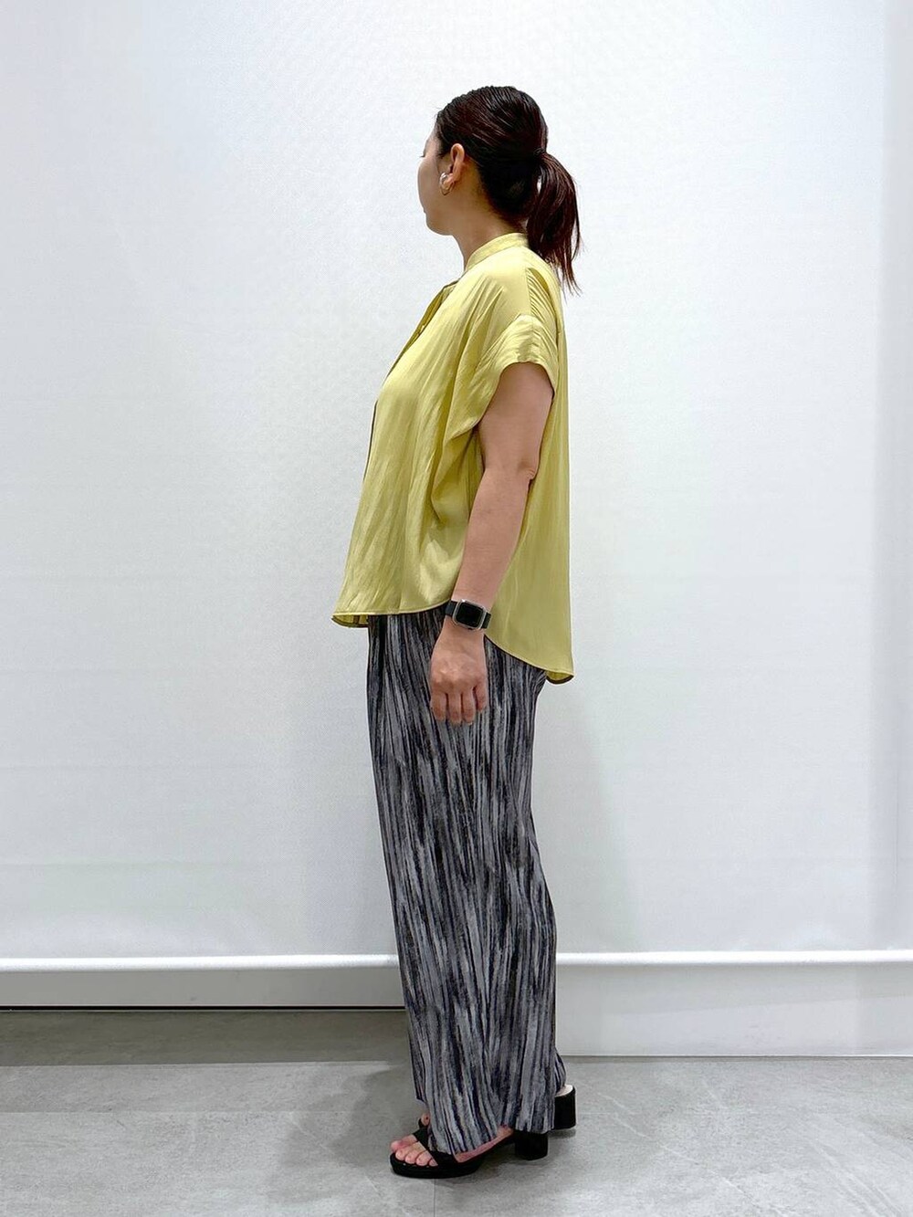グレー系のその他パンツ、ブラック系のハンドバッグ、イエロー系のシャツ/ブラウスを着用したレディースの夏コーディネートの3枚目の写真
