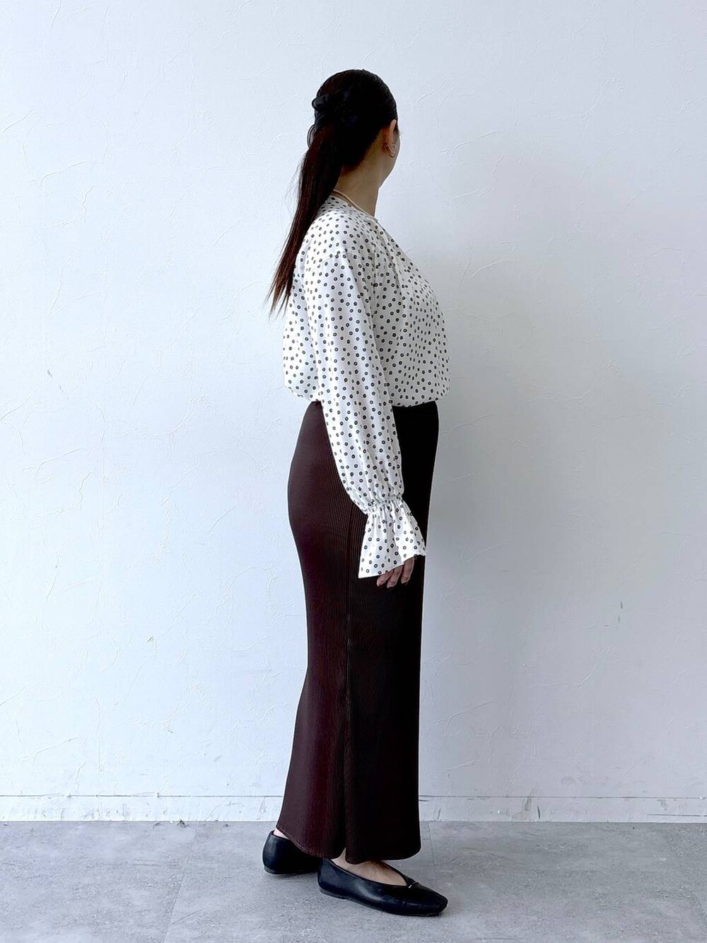 ブラック系のパンプス、ブラック系のトートバッグ、ホワイト系のシャツ/ブラウスを着用したレディースの冬コーディネートの5枚目の写真