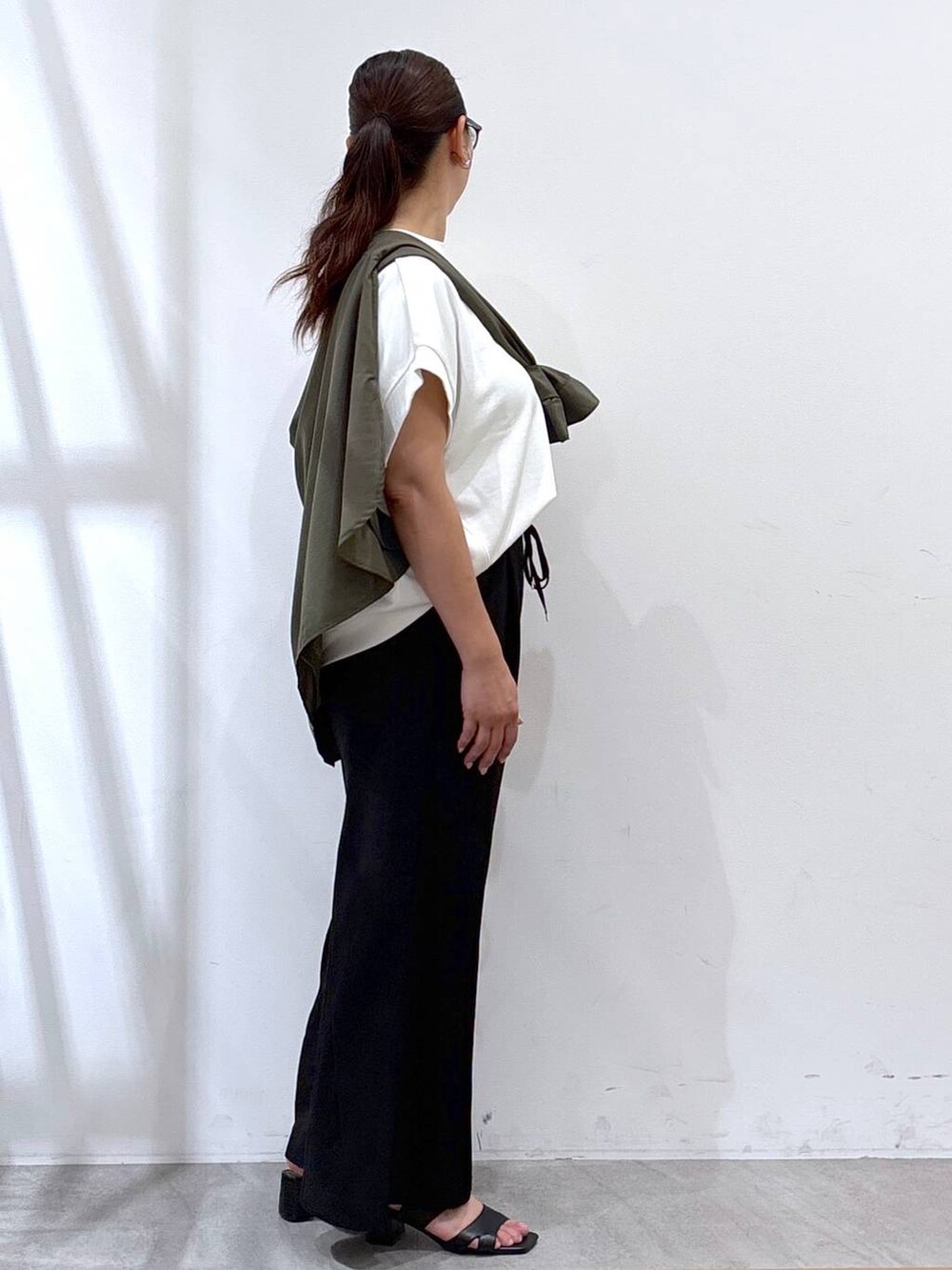 ブラック系のその他パンツ、ブラック系のサンダル、ホワイト系のTシャツ/カットソーを着用したレディースの秋コーディネートの5枚目の写真