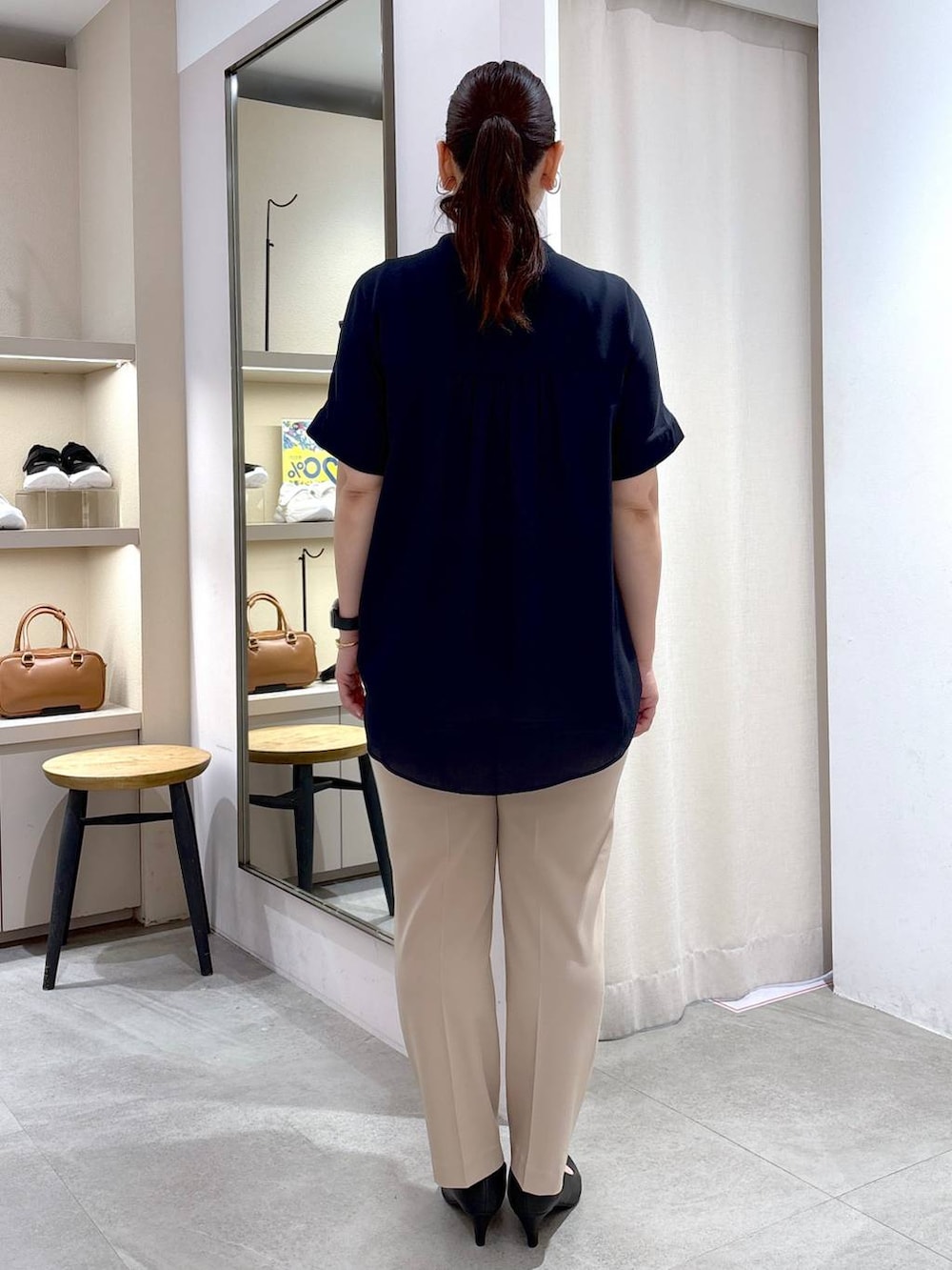 ブラック系のパンプス、ブラック系のハンドバッグ、ベージュ系のその他パンツを着用したレディースの春コーディネートの4枚目の写真