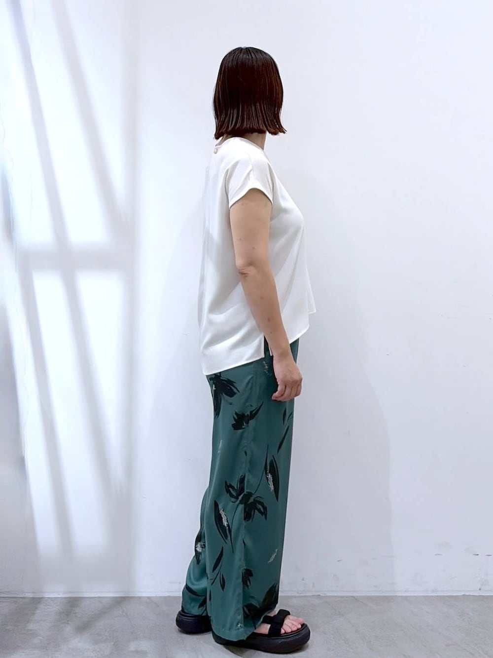 グリーン系のその他パンツ、ブラック系のかごバッグ、ホワイト系のシャツ/ブラウスを着用したレディースの夏コーディネートの4枚目の写真