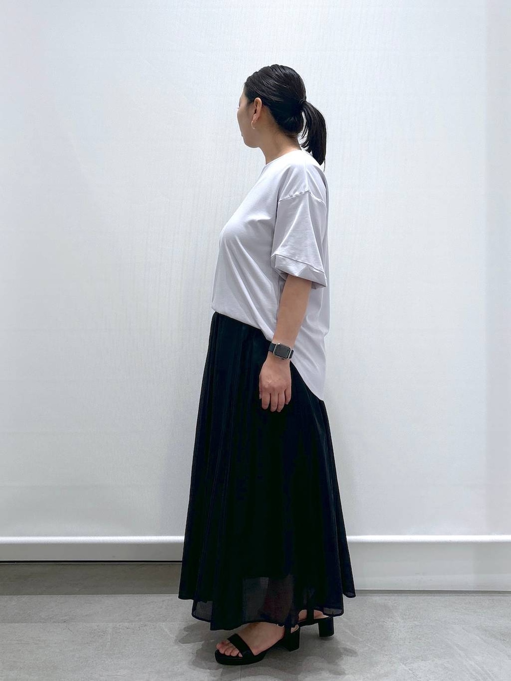 グレー系のTシャツ/カットソー、ブラック系のサンダル、ブラック系のスカートを着用したレディースの夏コーディネートの3枚目の写真
