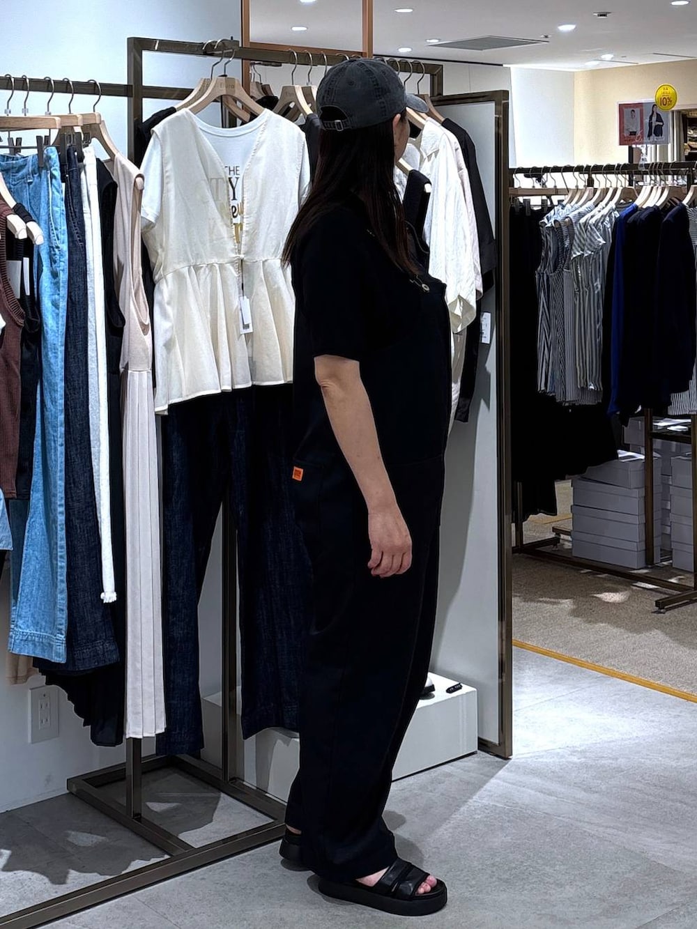 ブラック系のサンダル、ブラック系のニット/セーター、ブラック系のサロペット/オーバーオールを着用したレディースの春コーディネートの5枚目の写真