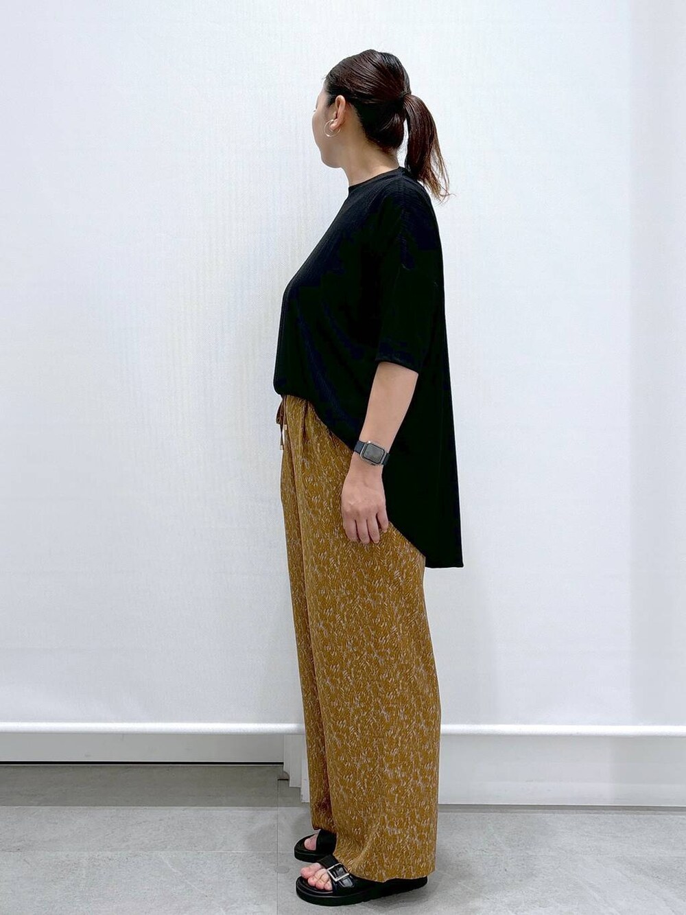 ブラック系のサンダル、ブラック系のTシャツ/カットソー、ブラック系のハンドバッグを着用したレディースの夏コーディネートの3枚目の写真