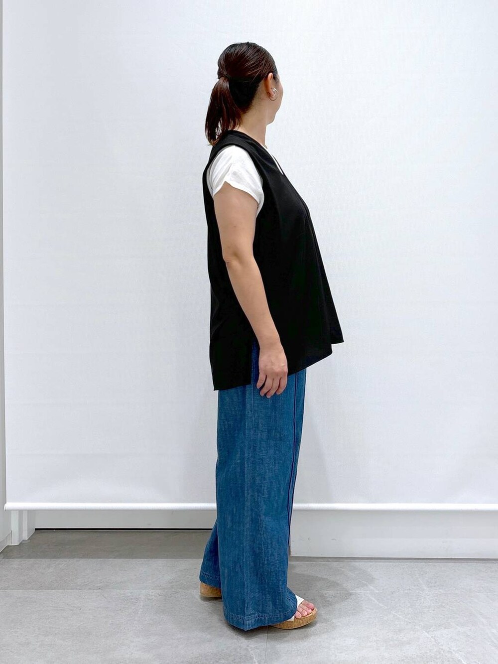 ブルー系のデニムパンツ、ブラック系のシャツ/ブラウス、ホワイト系のサンダルを着用したレディースの夏コーディネートの5枚目の写真