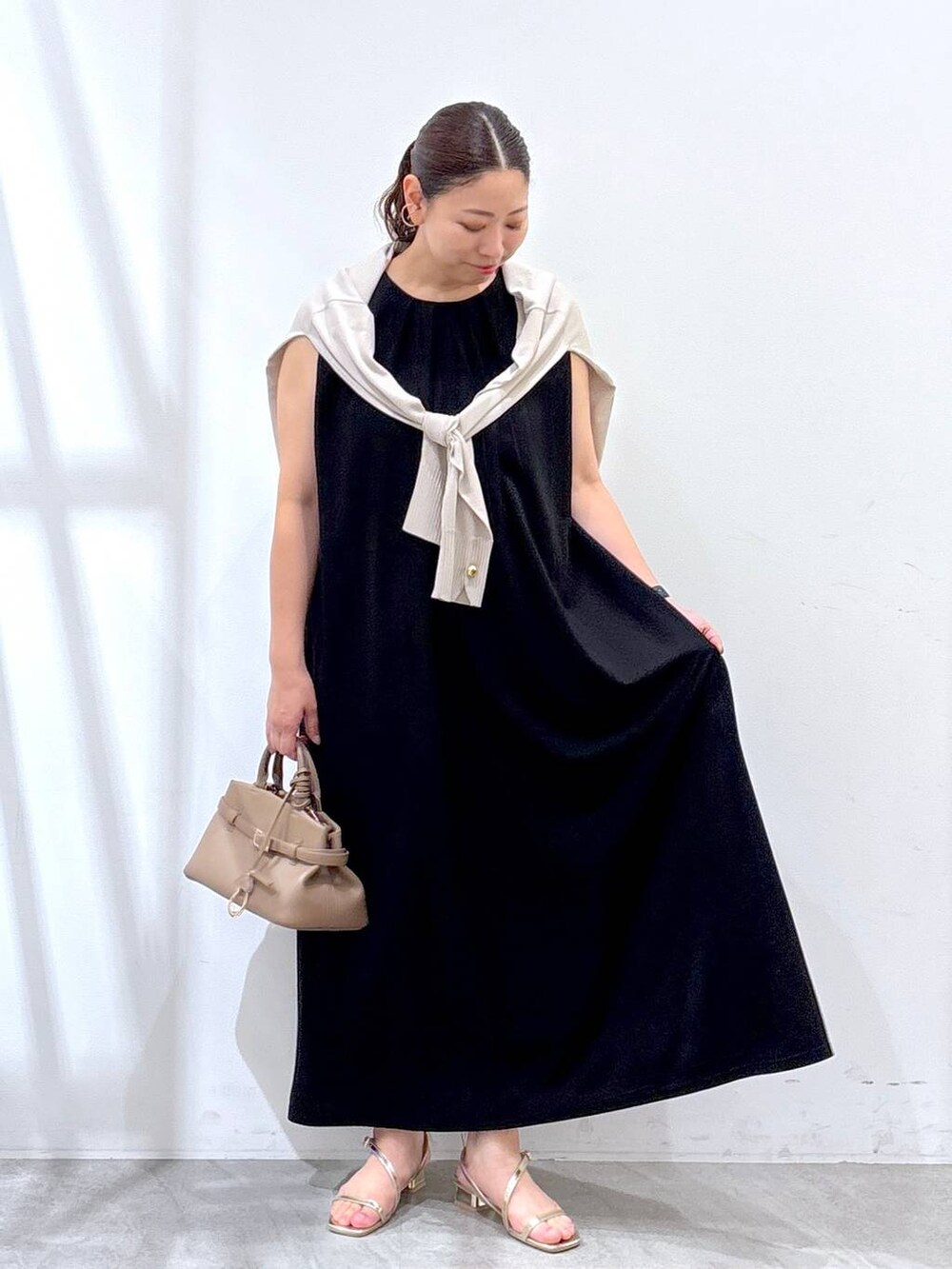 ゴールド系のサンダル、ベージュ系のカーディガン/ボレロを着用したレディースの夏コーディネートの2枚目の写真