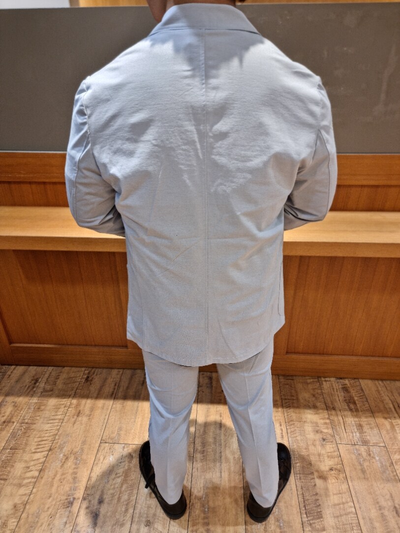 グレー系のスラックス、グレー系のテーラードジャケット、グレー系のセットアップを着用したメンズの夏コーディネートの4枚目の写真