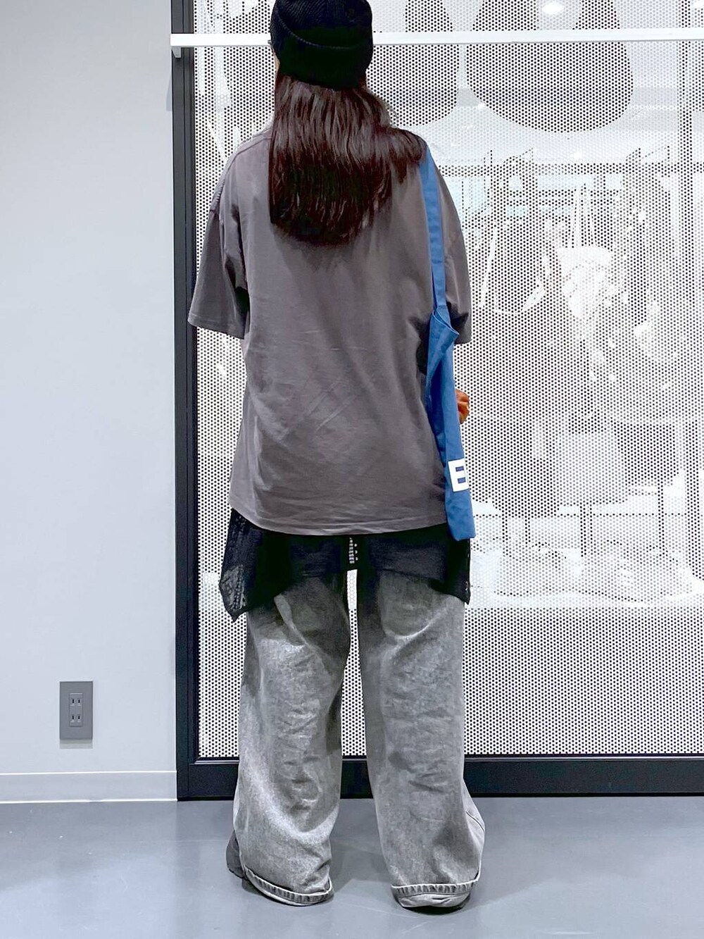 ブラック系のデニムパンツ、ブルー系のトートバッグ、グレー系のTシャツ/カットソーを着用したレディースの夏コーディネートの4枚目の写真
