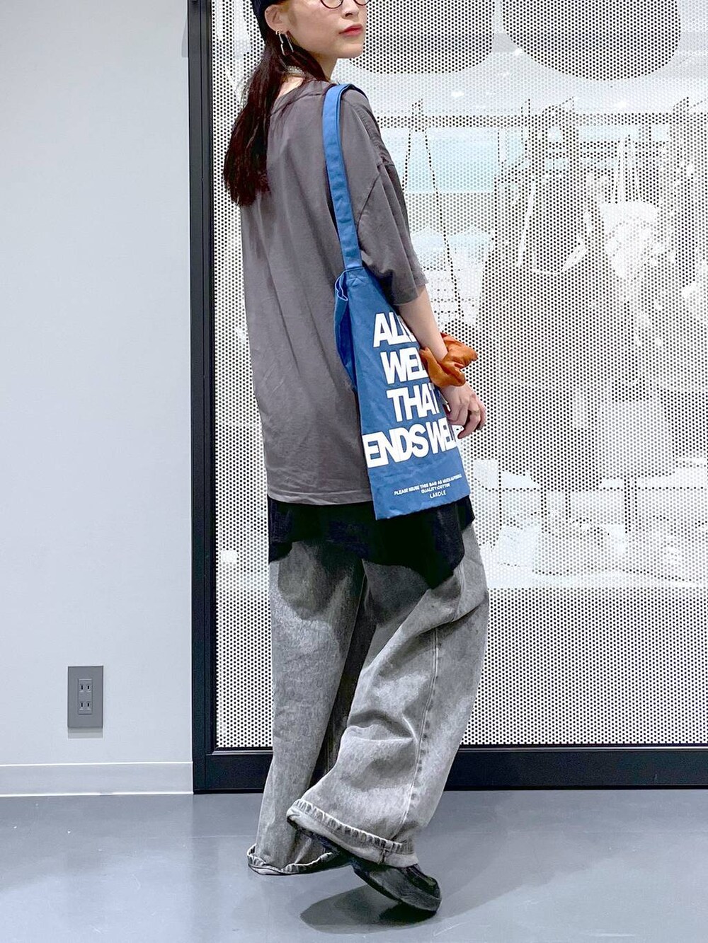 ブラック系のデニムパンツ、ブルー系のトートバッグ、グレー系のTシャツ/カットソーを着用したレディースの夏コーディネートの5枚目の写真