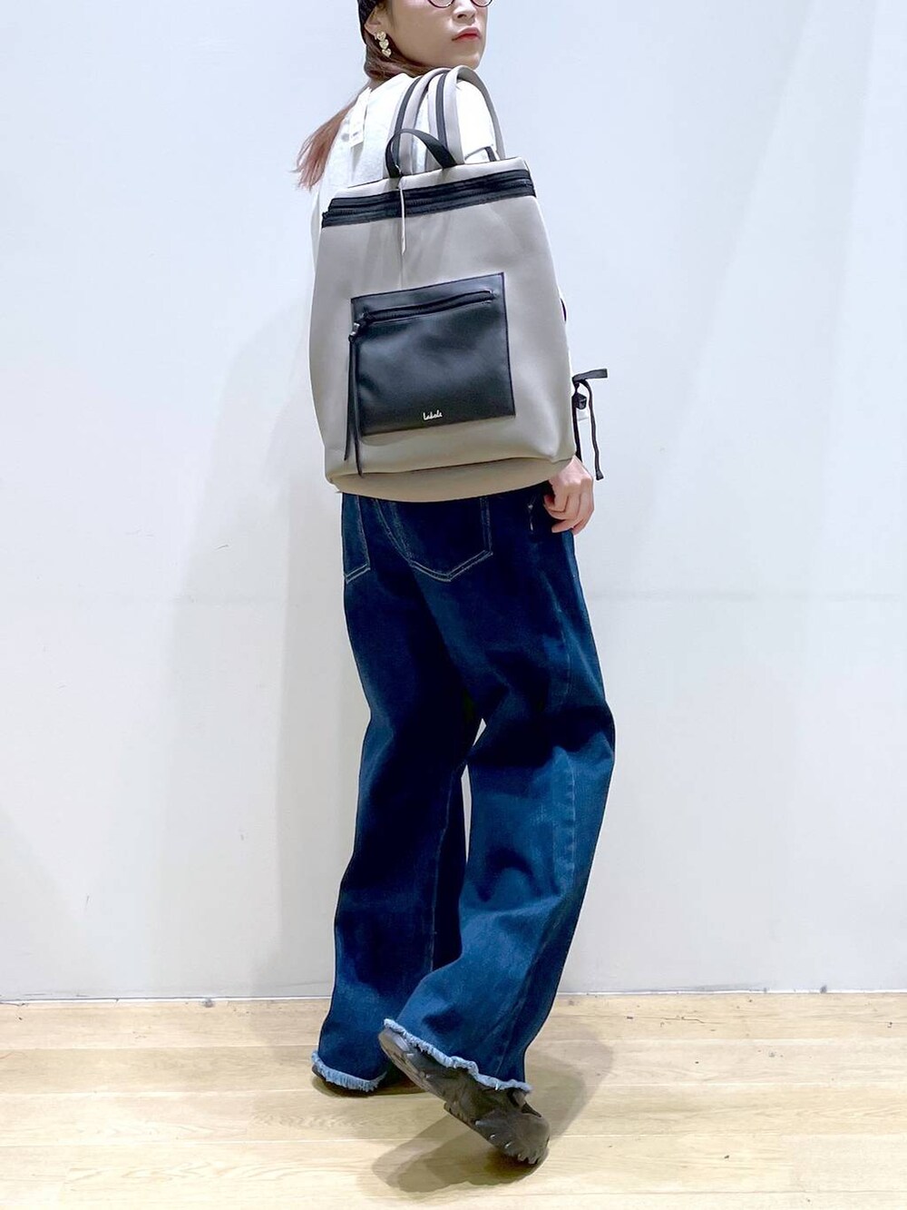 ブラック系のスニーカー、グレー系のバックパック/リュック、ベージュ系のスウェットを着用したレディースの秋コーディネートの5枚目の写真