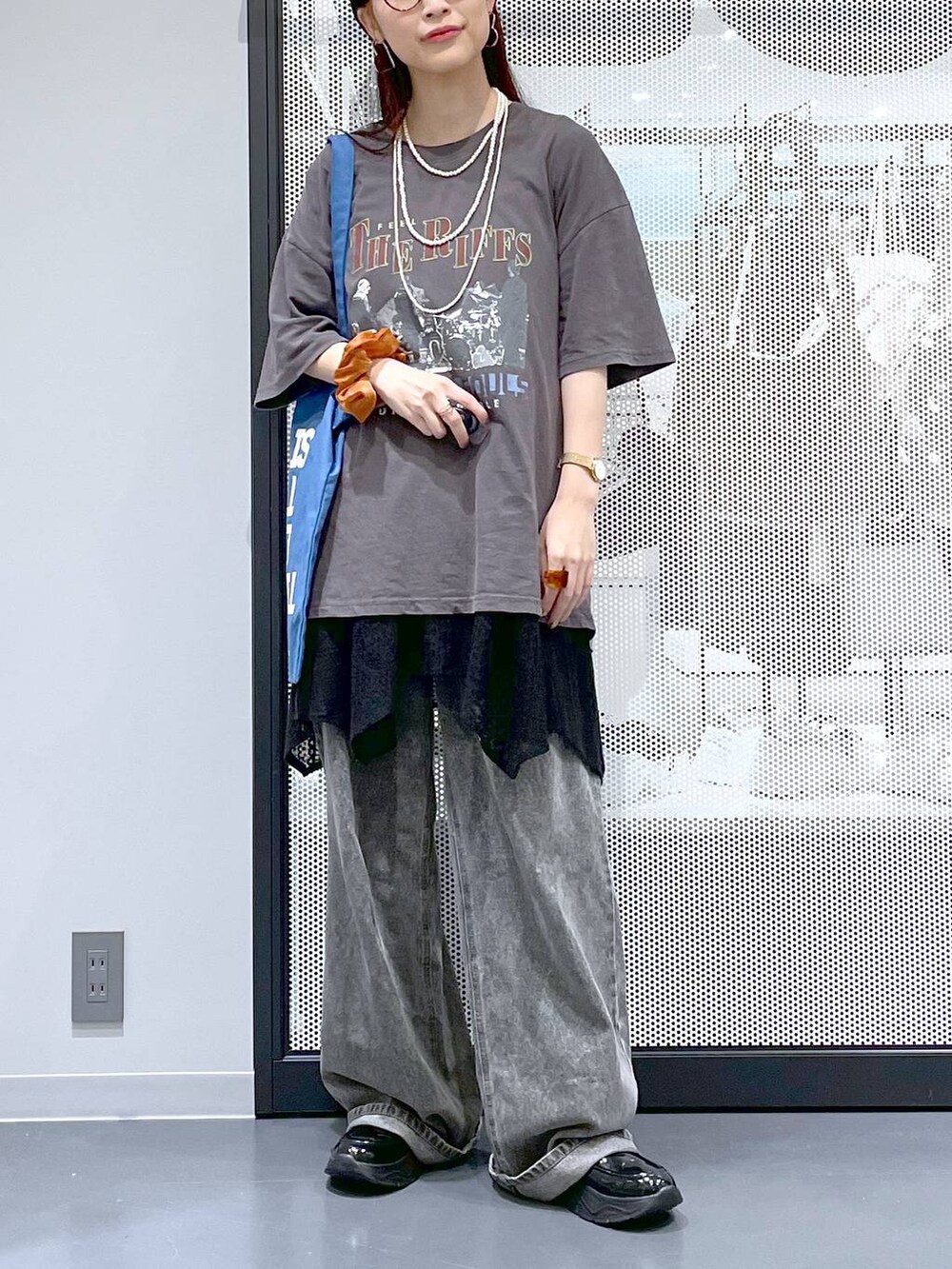 ブラック系のデニムパンツ、ブルー系のトートバッグ、グレー系のTシャツ/カットソーを着用したレディースの夏コーディネートの6枚目の写真
