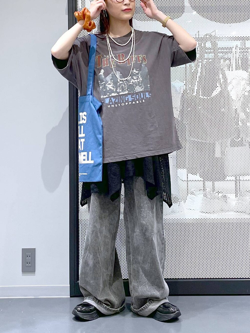 ブラック系のデニムパンツ、ブルー系のトートバッグ、グレー系のTシャツ/カットソーを着用したレディースの夏コーディネートの9枚目の写真