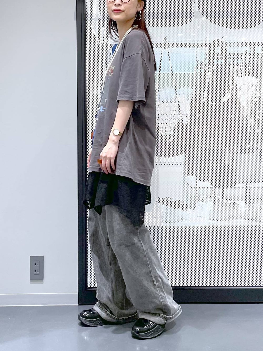 ブラック系のデニムパンツ、ブルー系のトートバッグ、グレー系のTシャツ/カットソーを着用したレディースの夏コーディネートの3枚目の写真