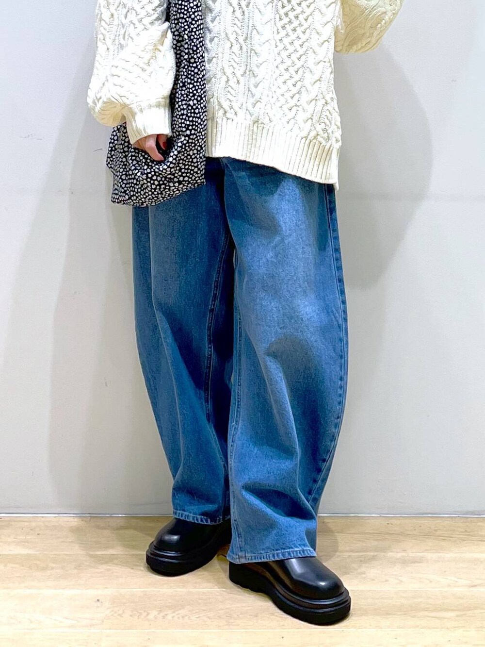 ブルー系のデニムパンツ、ブラック系のブーツ、ホワイト系のニット/セーターを着用したレディースの冬コーディネートの8枚目の写真