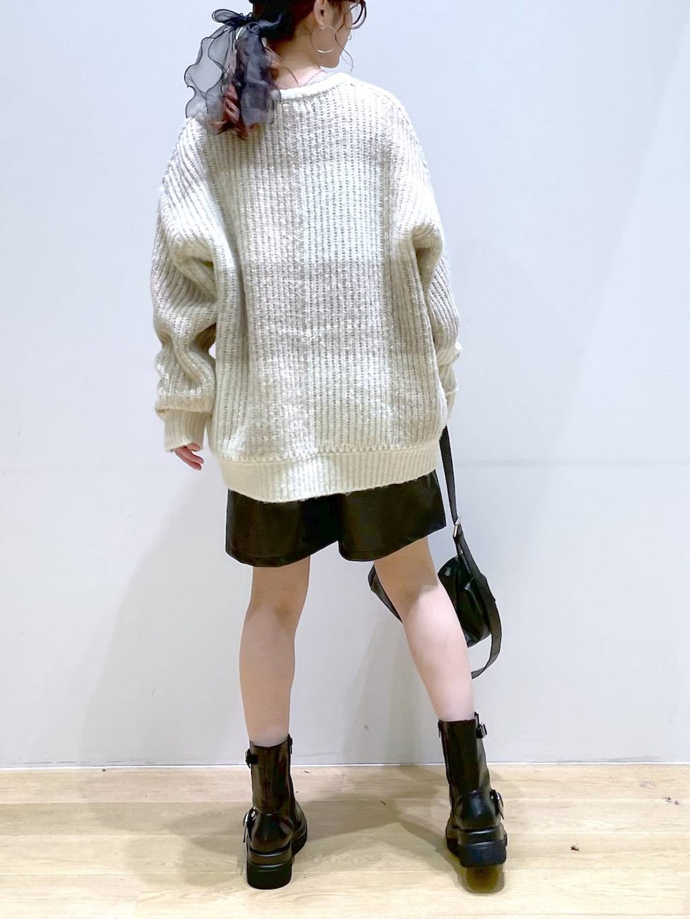 ベージュ系のニット/セーター、ブラック系のブーツ、ブラック系のショルダーバッグを着用したレディースの冬コーディネートの4枚目の写真