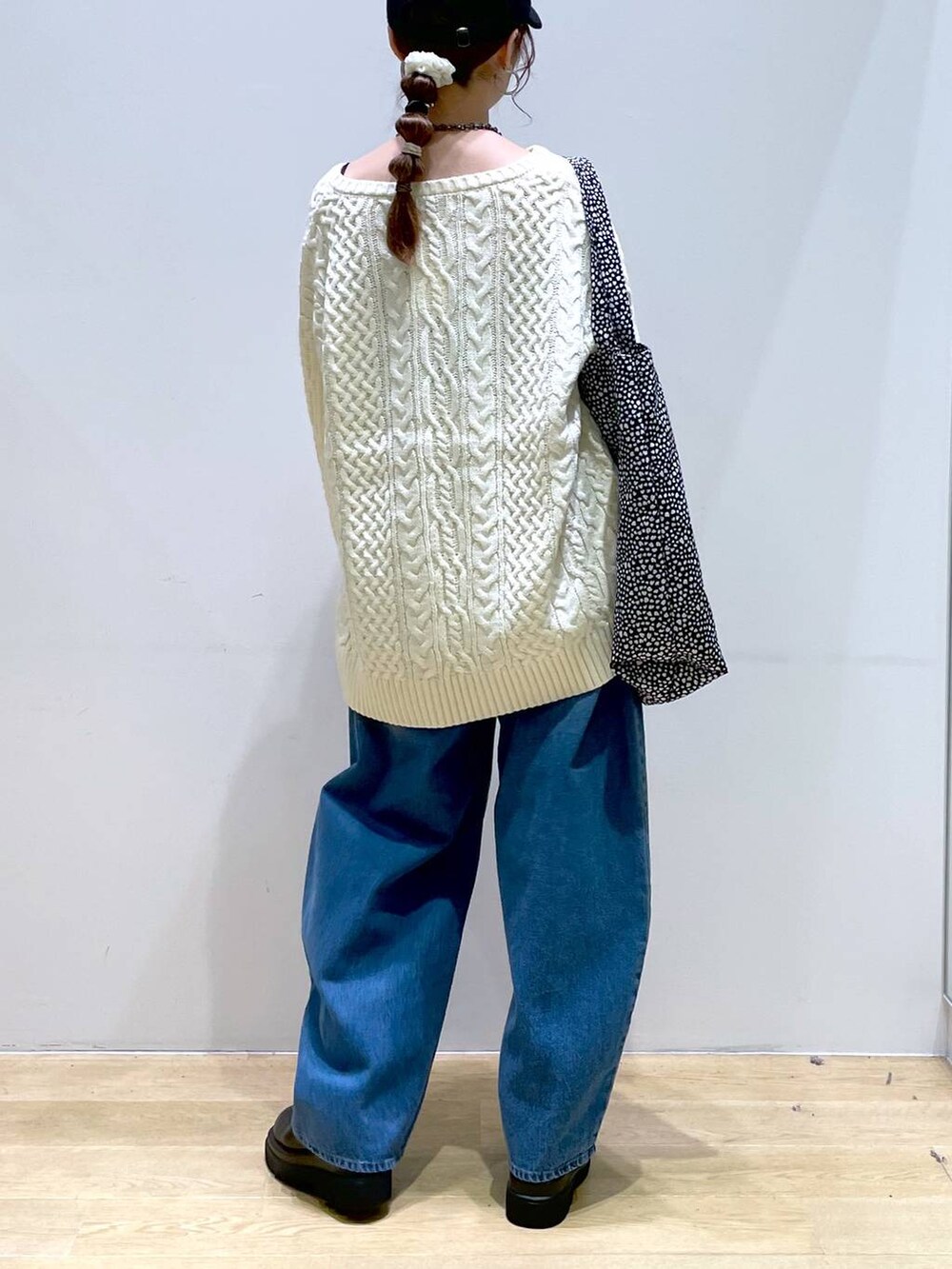 ブルー系のデニムパンツ、ブラック系のブーツ、ホワイト系のニット/セーターを着用したレディースの冬コーディネートの4枚目の写真