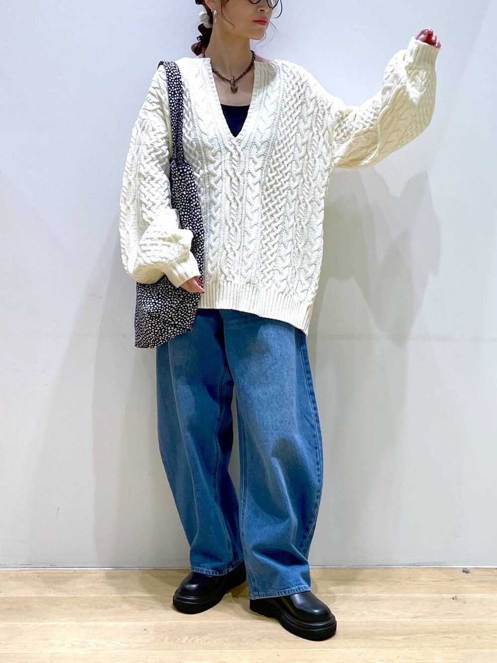ブルー系のデニムパンツ、ブラック系のブーツ、ホワイト系のニット/セーターを着用したレディースの冬コーディネートの9枚目の写真