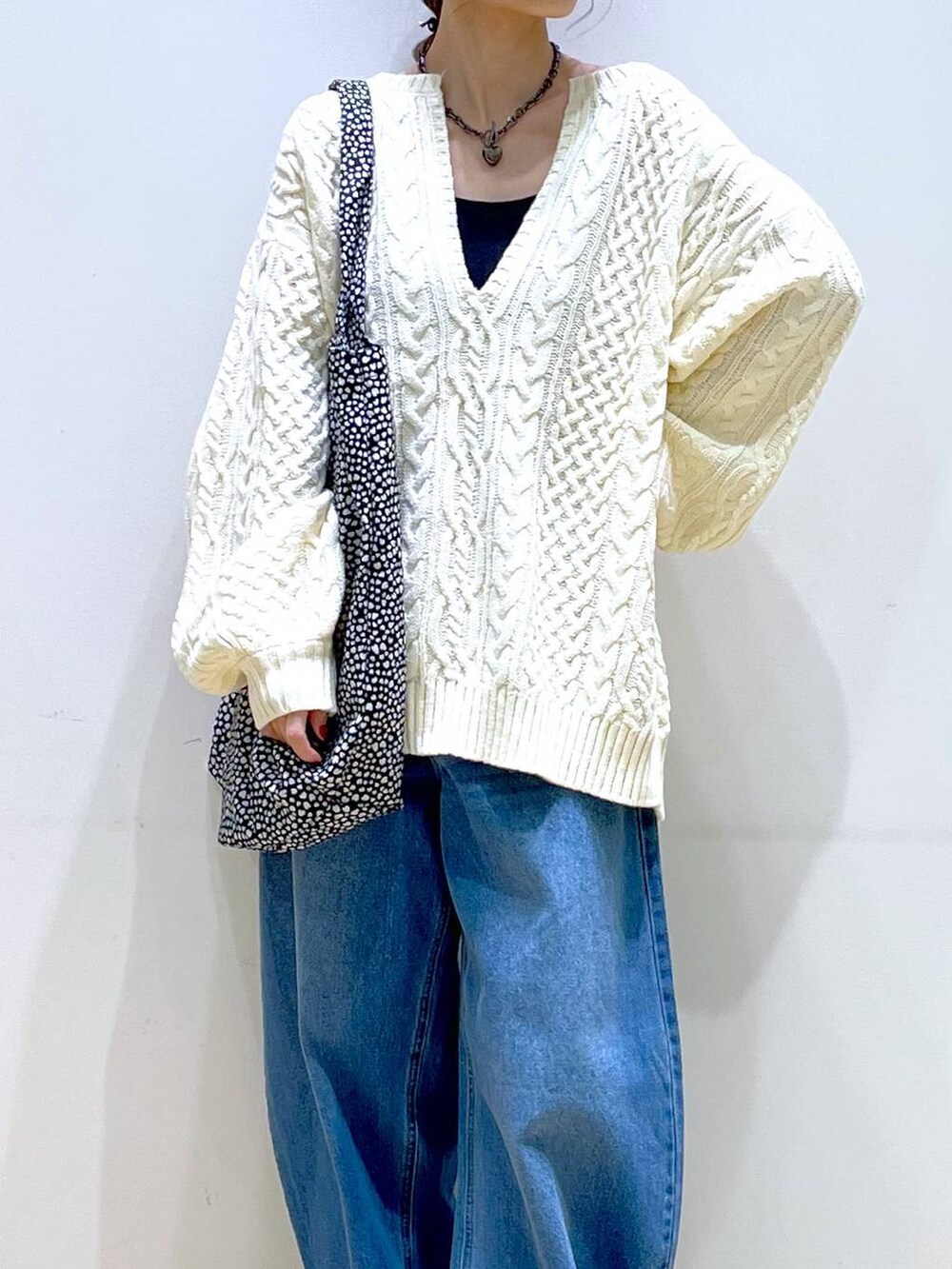 ブルー系のデニムパンツ、ブラック系のブーツ、ホワイト系のニット/セーターを着用したレディースの冬コーディネートの7枚目の写真