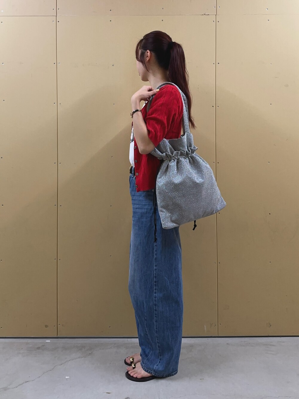 ブルー系のデニムパンツ、ホワイト系のTシャツ/カットソー、シルバー系のトートバッグを着用したレディースの夏コーディネートの2枚目の写真