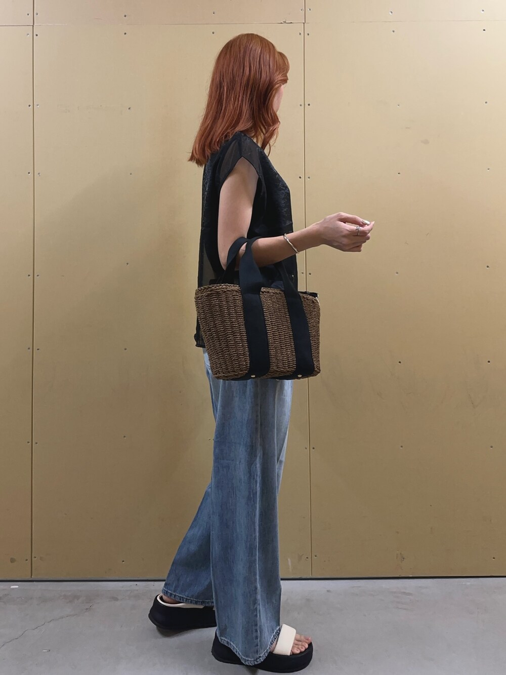 ブラック系のシャツ/ブラウス、ブルー系のデニムパンツ、ブラック系のかごバッグを着用したレディースの夏コーディネートの2枚目の写真