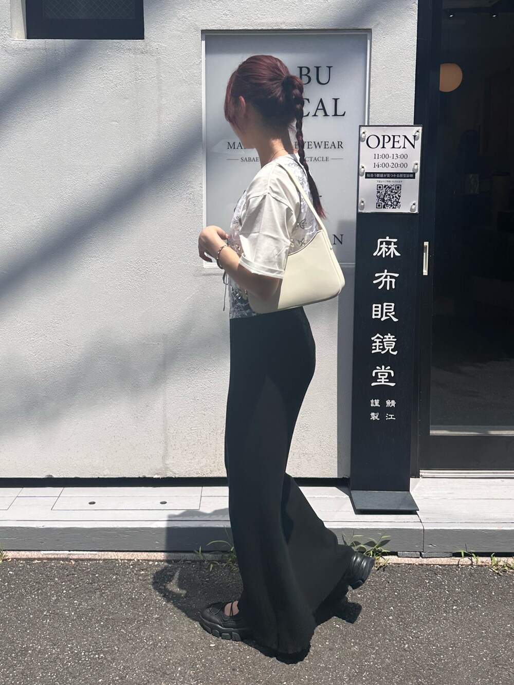 ブラック系のスカート、ブラック系のサンダル、シルバー系のベストを着用したレディースの夏コーディネートの4枚目の写真