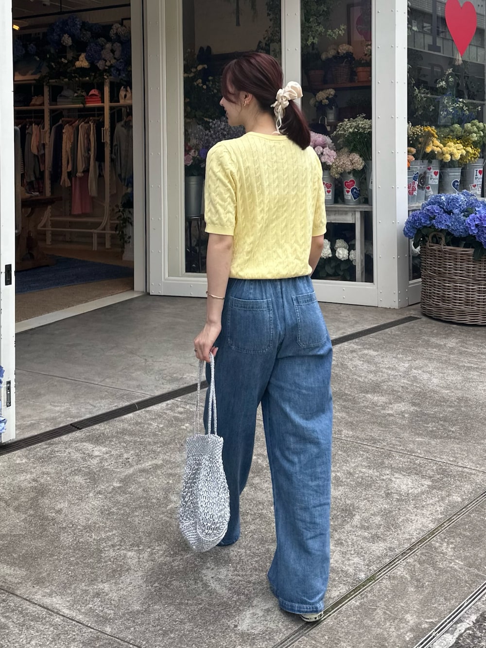 「スニーカー、デニム、パンツコーデ、夏ファッション、甘めカジュアル、サマーニット、半袖ニット、デニムパンツ、デニムコーデ、ライトオンスデニム、イージーパンツ、巾着バッグ、メタルバッグ、シュシュ、お出かけコーデ」｜「fredy emueのFR刺繍ケーブル柄ポケ付きプルオーバー（ニット/セーター、イエロー系）」を使った、Maikaさん（レディース・163cm）の春コーディネートの2枚目の写真