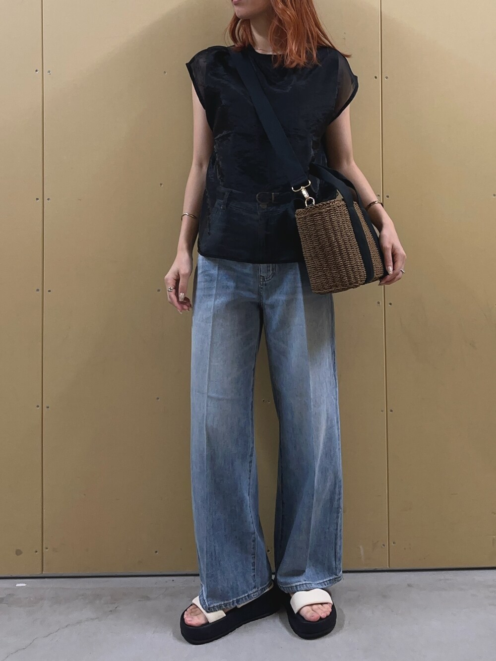 ブラック系のシャツ/ブラウス、ブルー系のデニムパンツ、ブラック系のかごバッグを着用したレディースの夏コーディネートの6枚目の写真