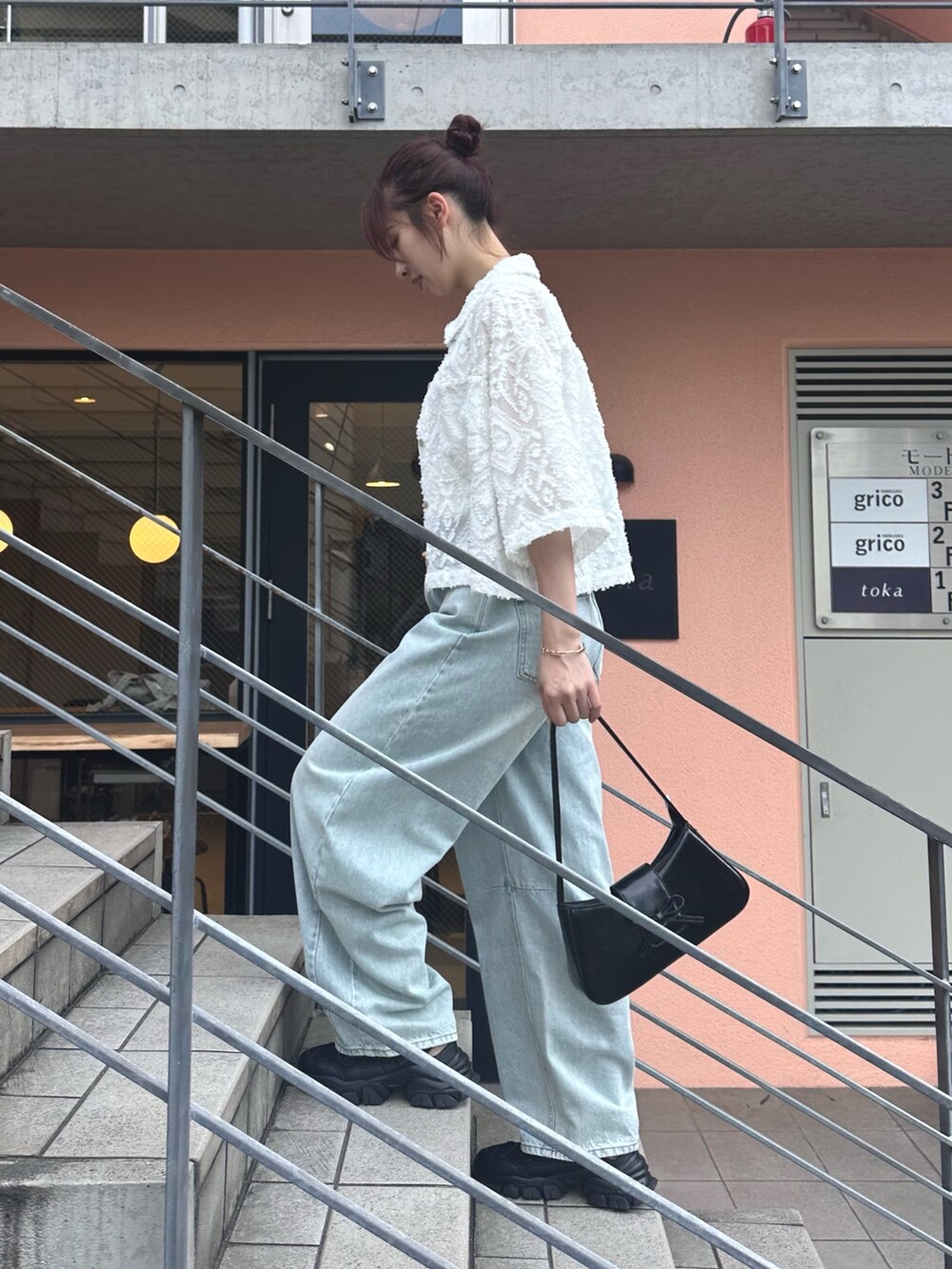 ブルー系のデニムパンツ、ブラック系のサンダル、ホワイト系のシャツ/ブラウスを着用したレディースの夏コーディネートの7枚目の写真