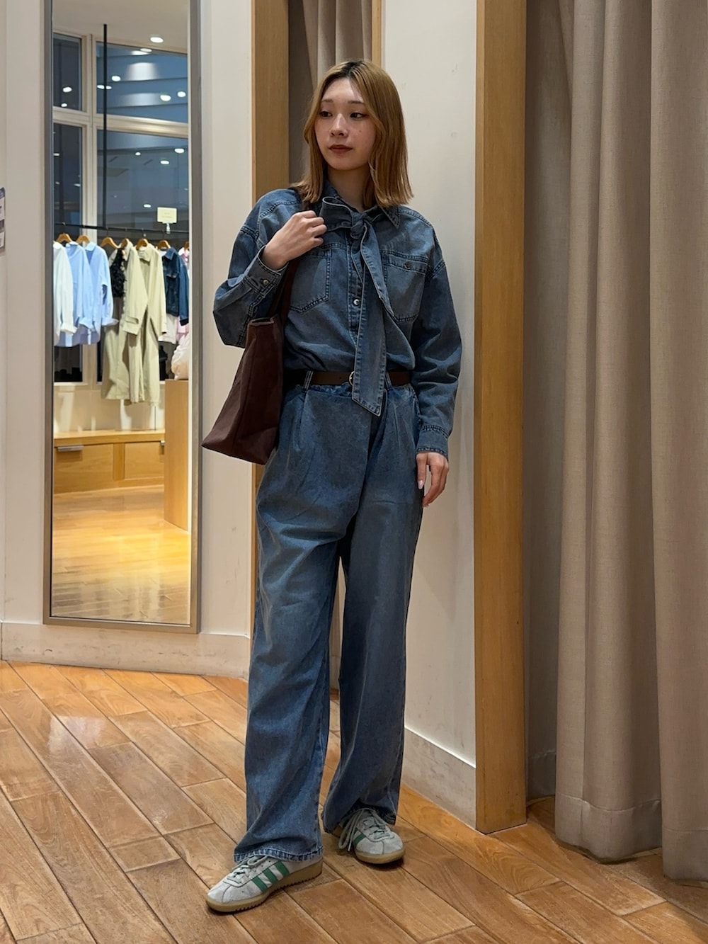 ブルー系のシャツ/ブラウス、ブルー系のデニムパンツ、ブラウン系のトートバッグを着用したレディースの春コーディネートの5枚目の写真